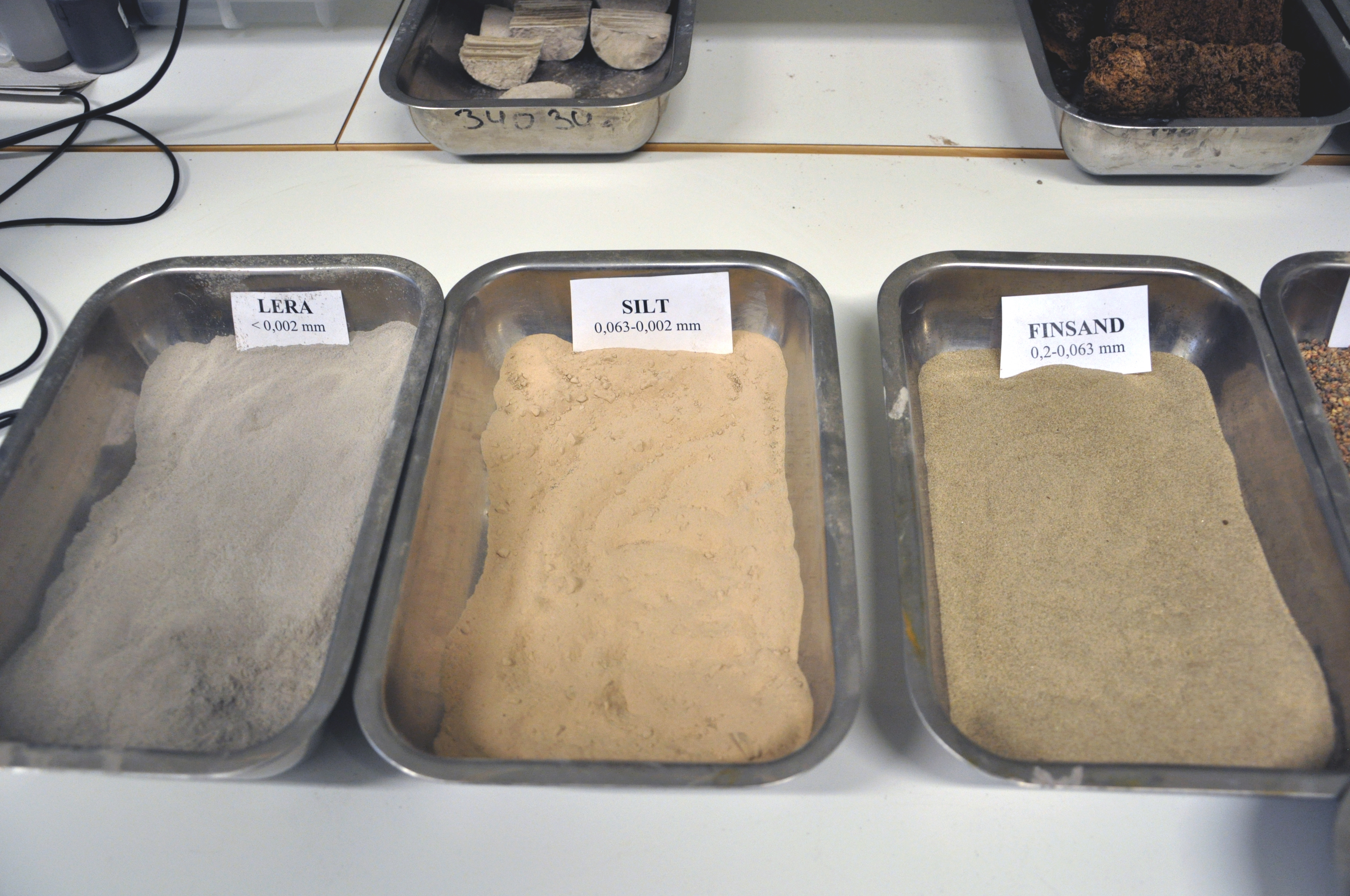 En utställning av olika typer av kornstorlek på brickor.