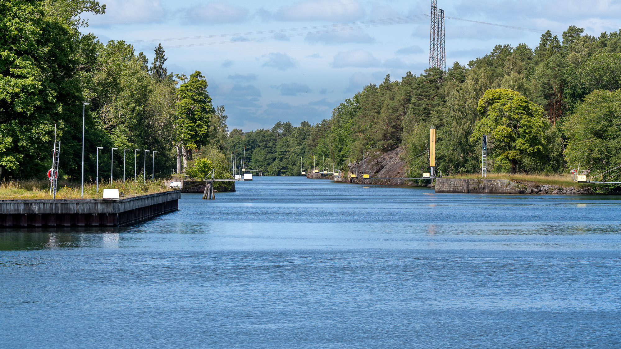 Ett vattendrag omgiven av träd och kraftledningar.